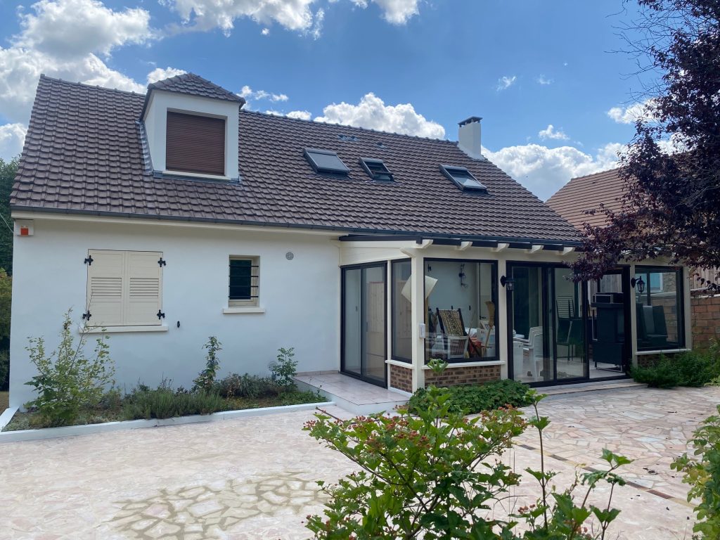 Maison avec façades rénovées, Beltoise Façades, et jardin paysager.