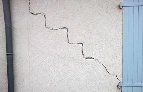 Fissures sur un mur intérieur, liées à Beltoise Façades.