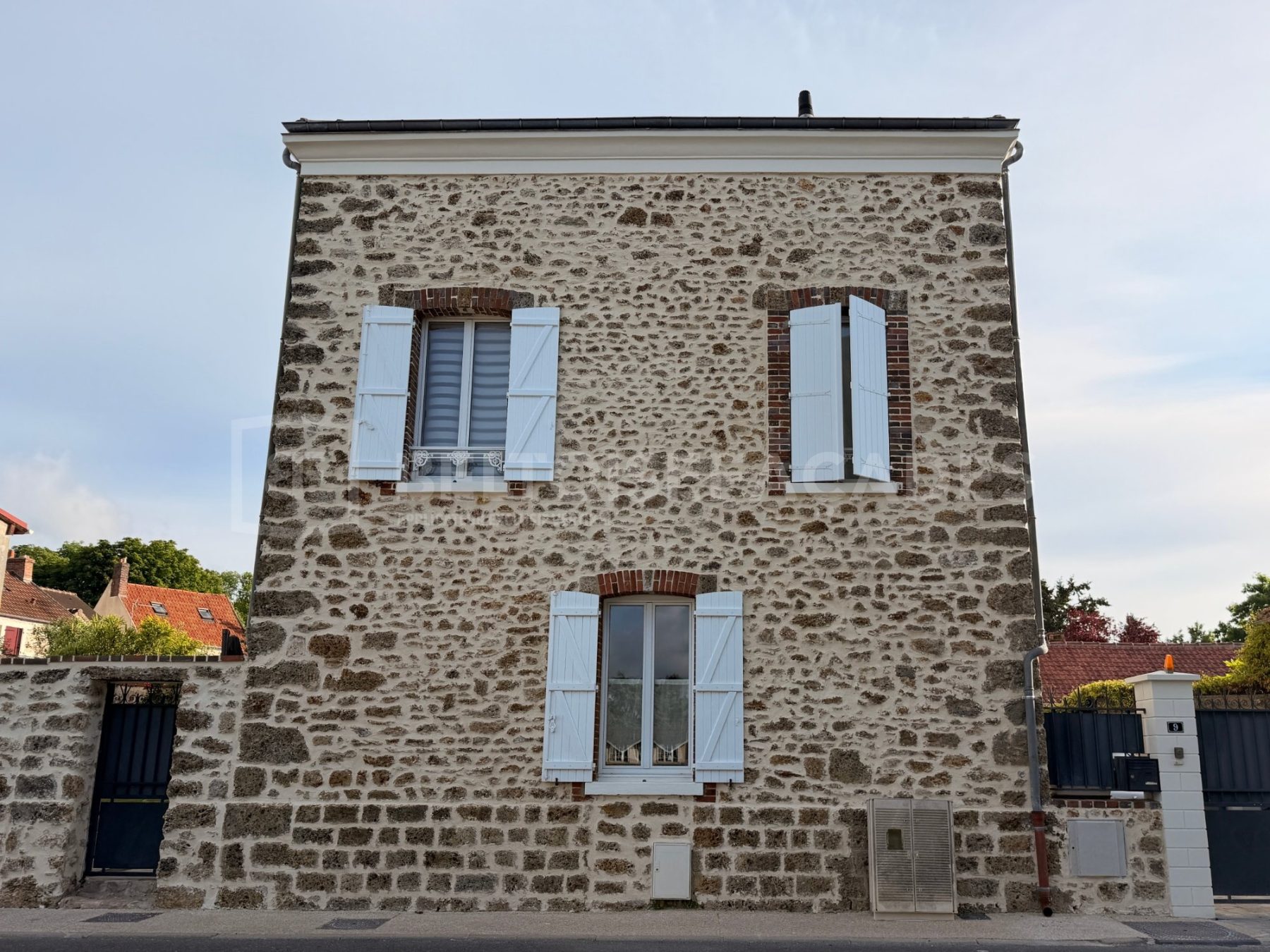 Façade en pierre avec volets blancs Beltoise Façades.