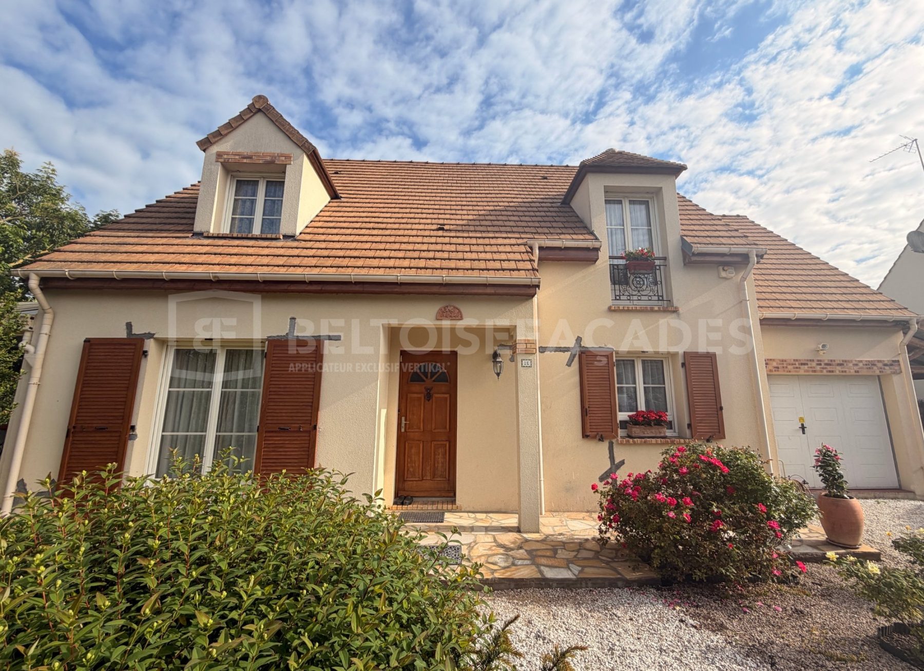 Maison rénovée par Beltoise Façades avec fenêtres à volets bois.