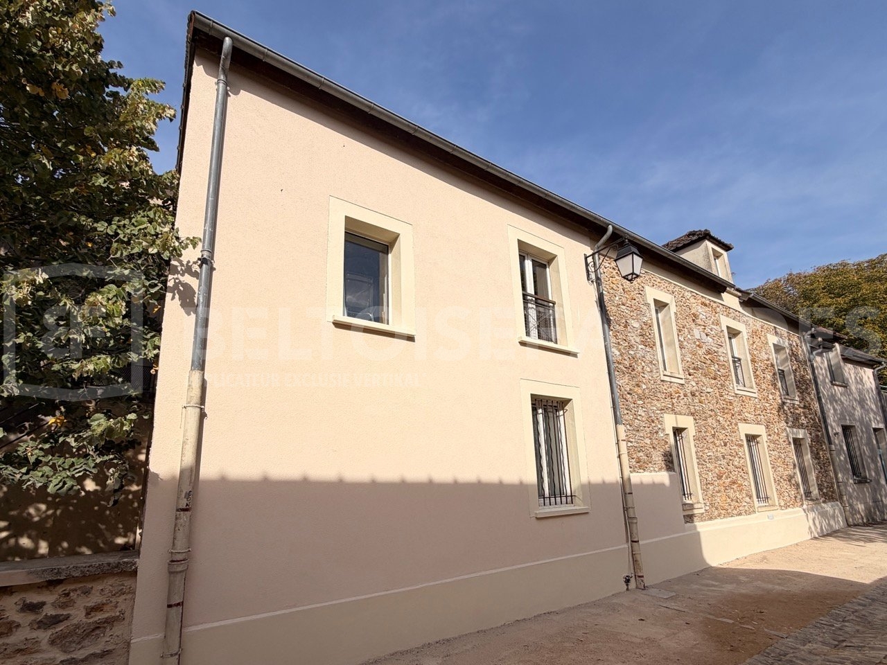 Bâtiment rénové par Beltoise Façades avec murs en pierre et crépi.